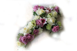 Cruz de condolencias, posición horizontal con floraciones en tonos pastel con rosas blancas y rosas