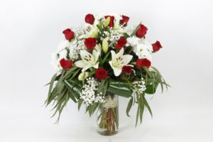 Ramo de una cara con rosas rojas, liliums blancos y floraciones blancas